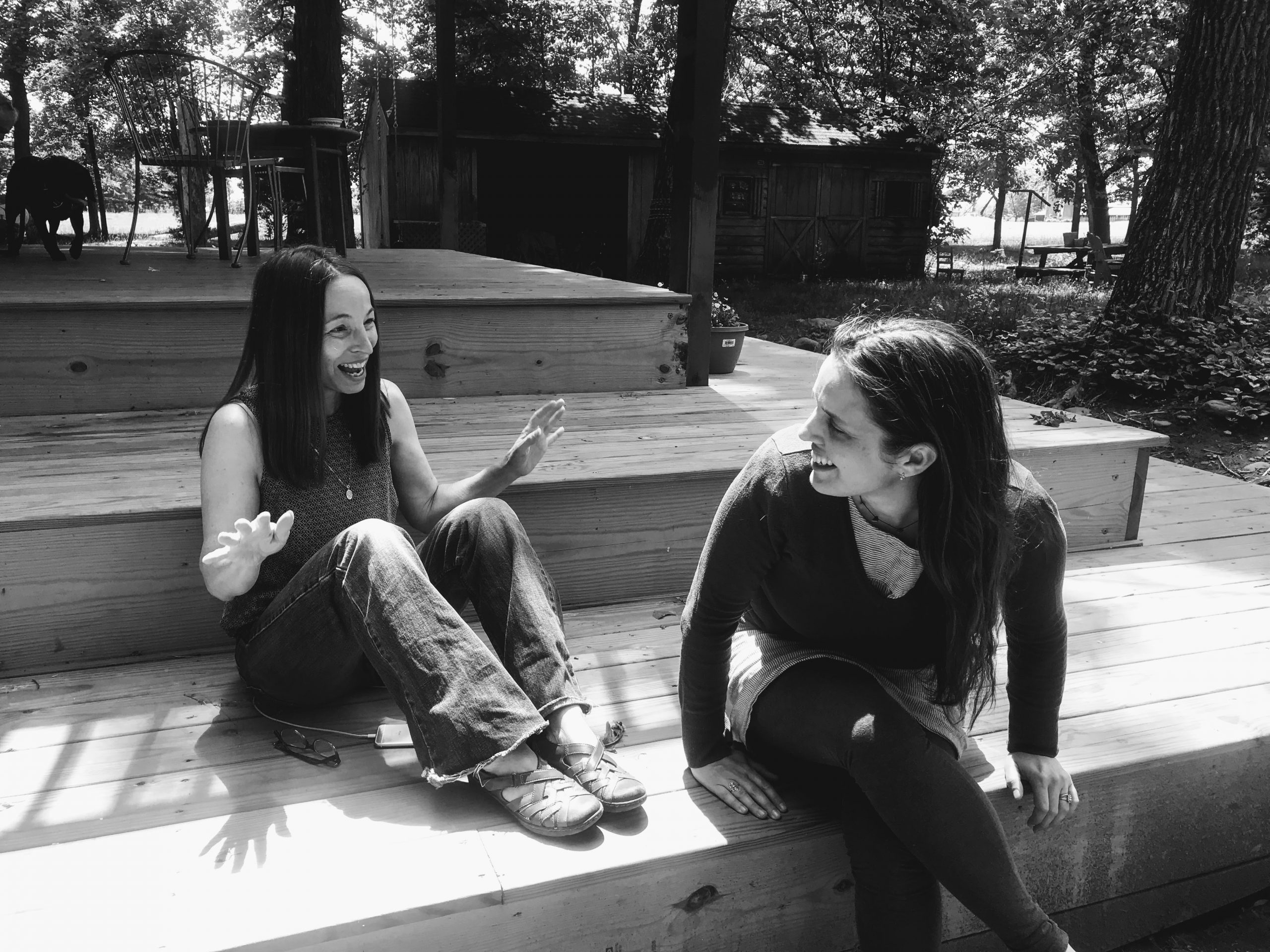 Aili and her aunt Marta, sitting on the porch. Marta is gesturing because she's at the high point of a funny story, and Aili is laughing.