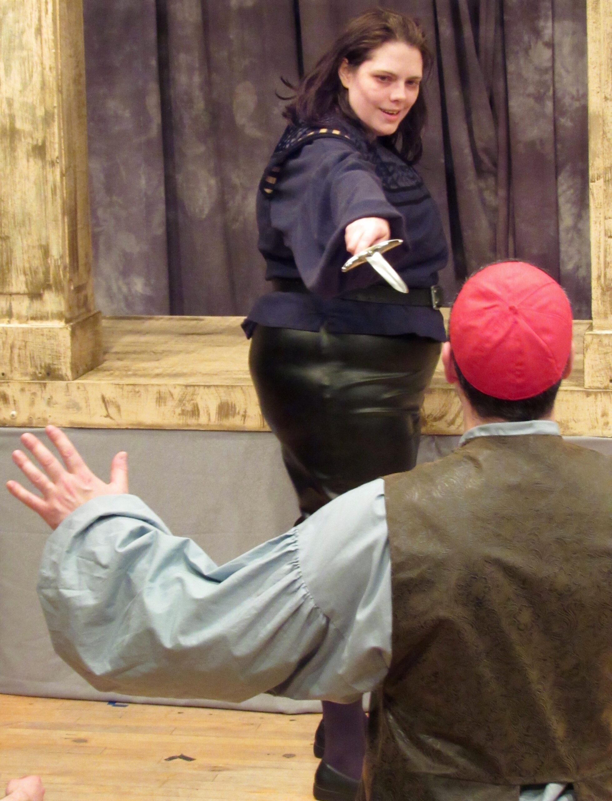 One actor threatening another with a knife.