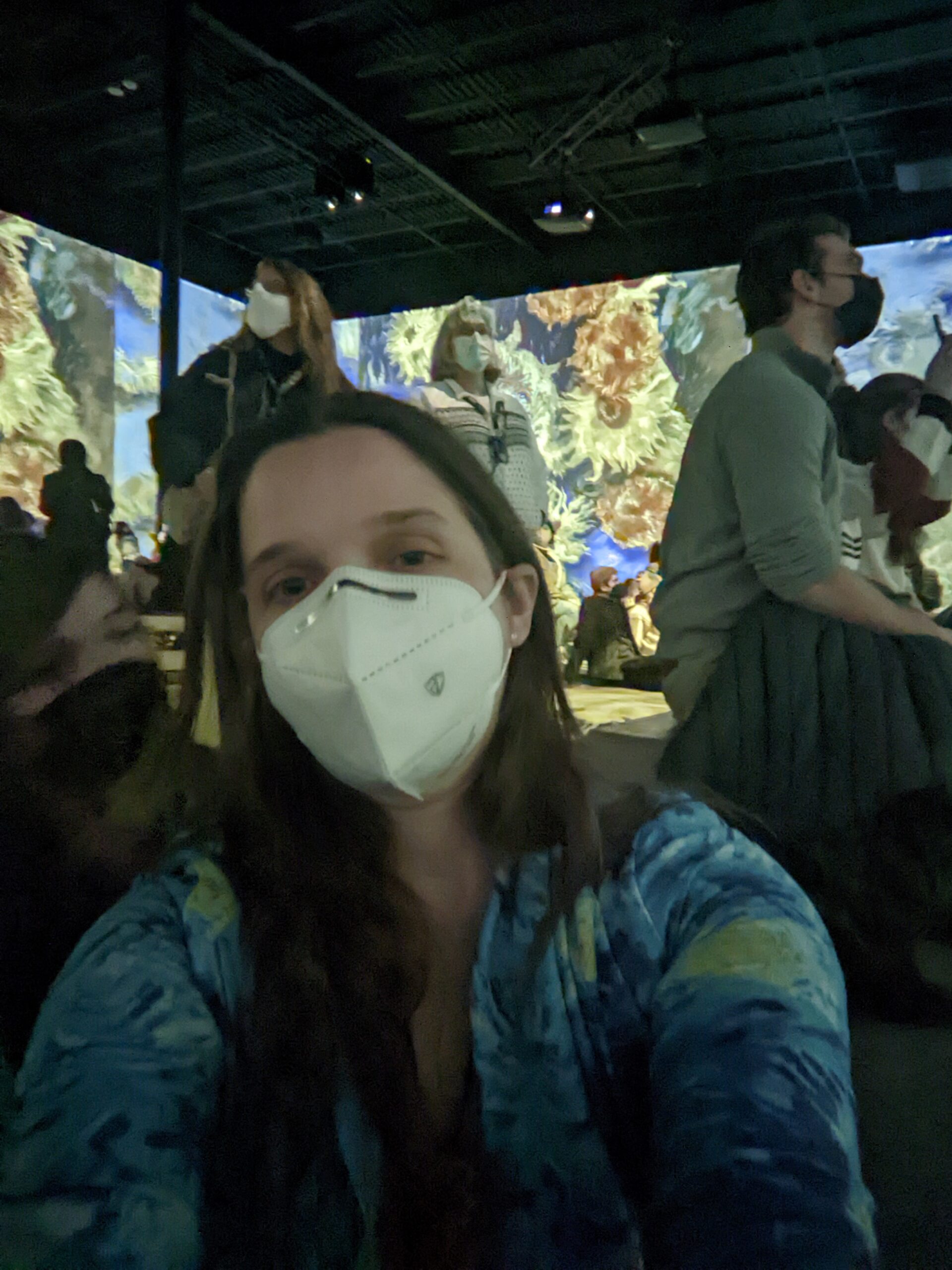 Aili takes a selfie in the projection room, with sunflowers on the wall behind her.