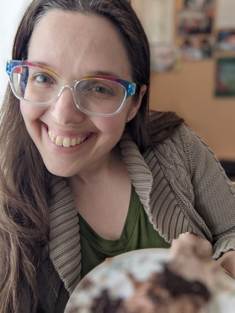 Aili grinning with a piece of leftover birthday cake.