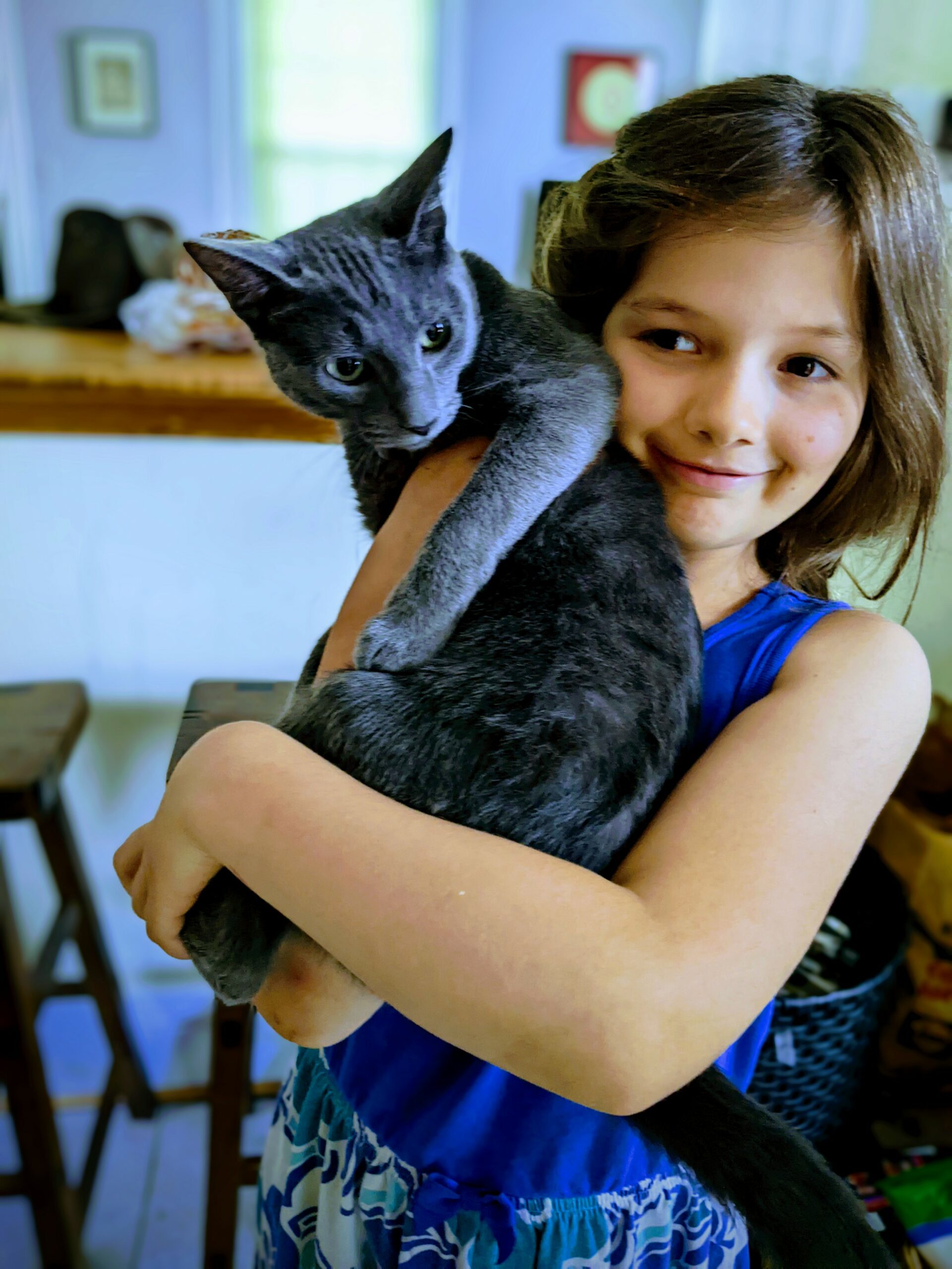 Petra holding a gray cat. Both are smiling.