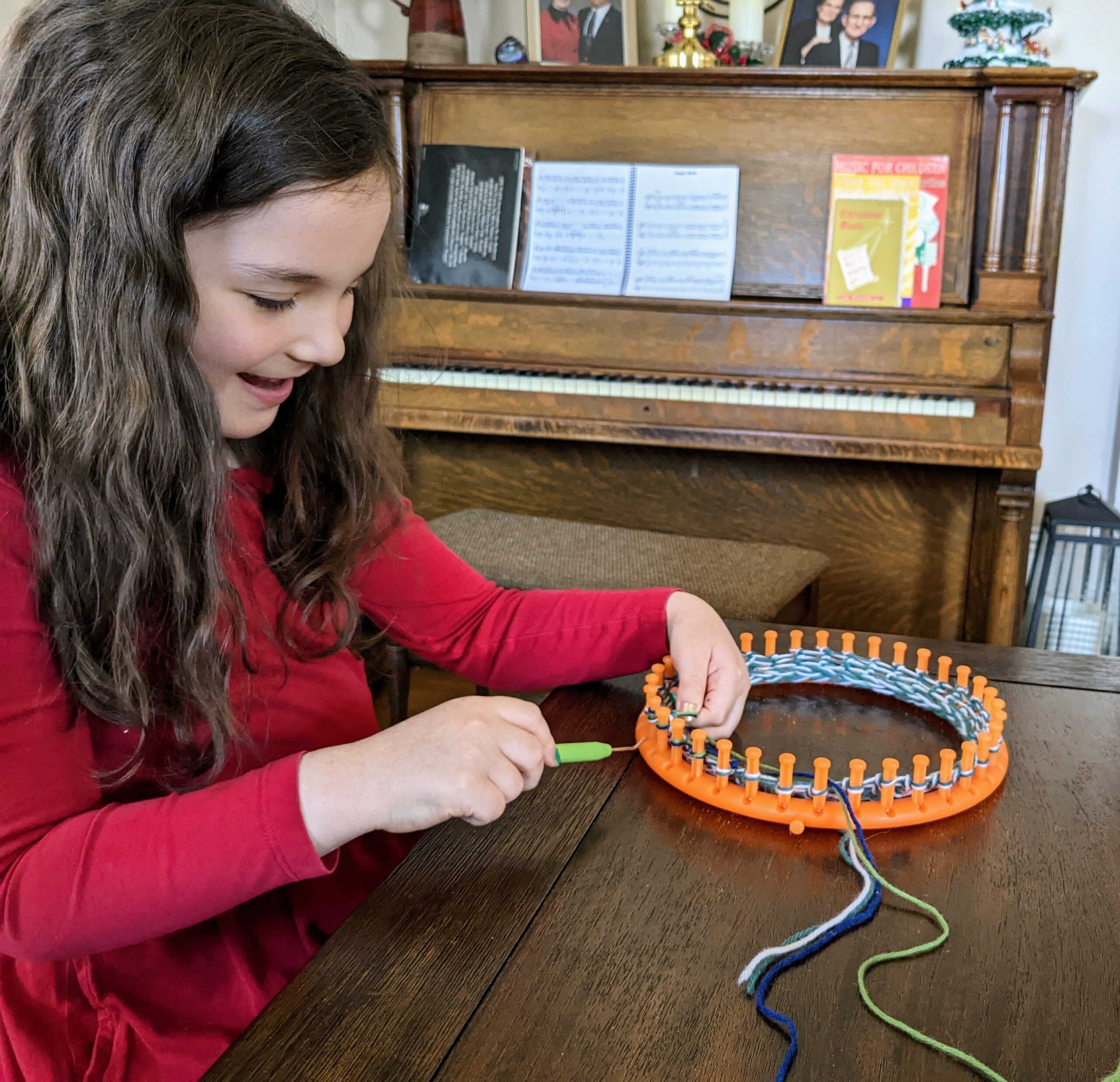 Elora making a hat on a circular knitting loom