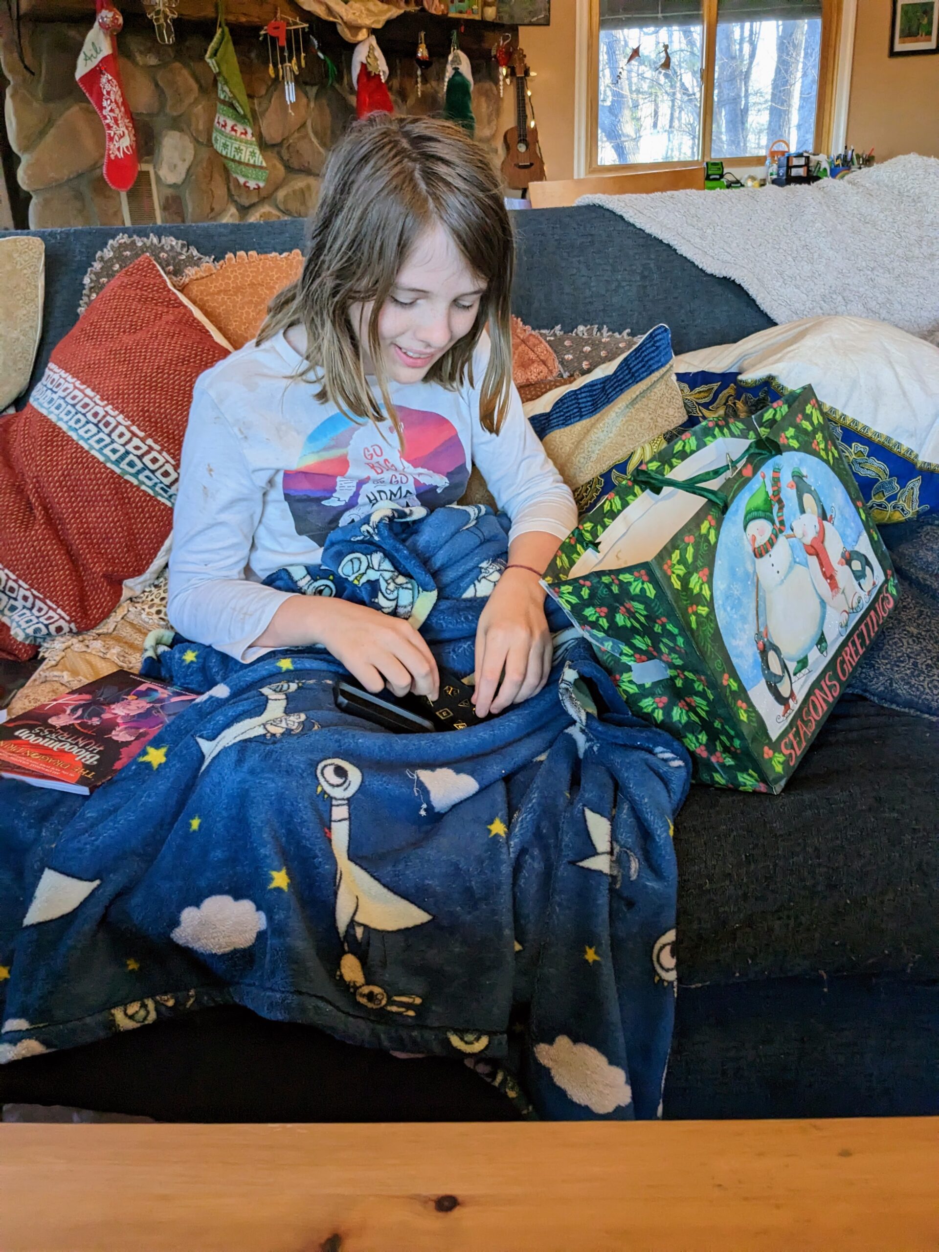 Silas, on the couch, opening a gift.