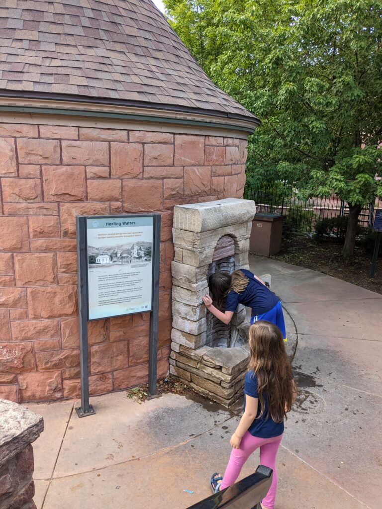 Silas drinking from the spring while Petra watches